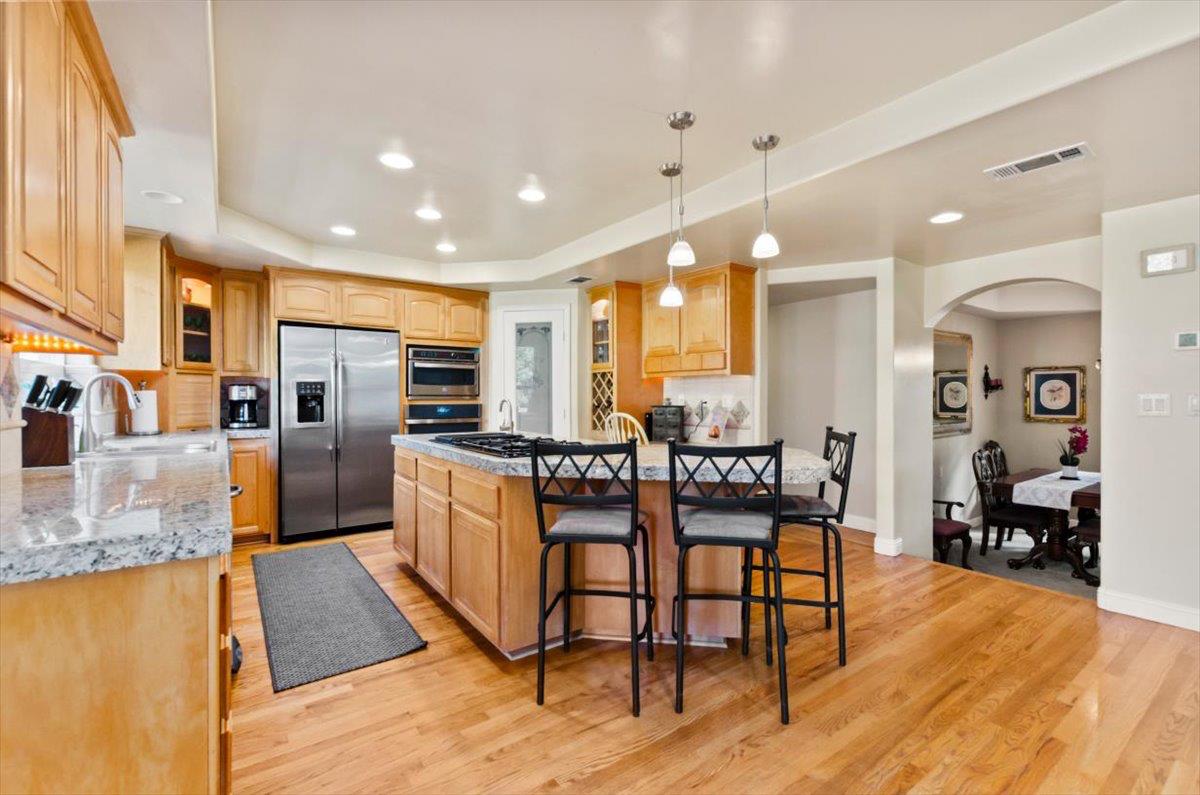 3720 Four Springs Drive Rescue, CA 95672 - Photo 6 of 34 a kitchen with stainless steel appliances granite countertop a stove top oven a sink a dining table and chairs