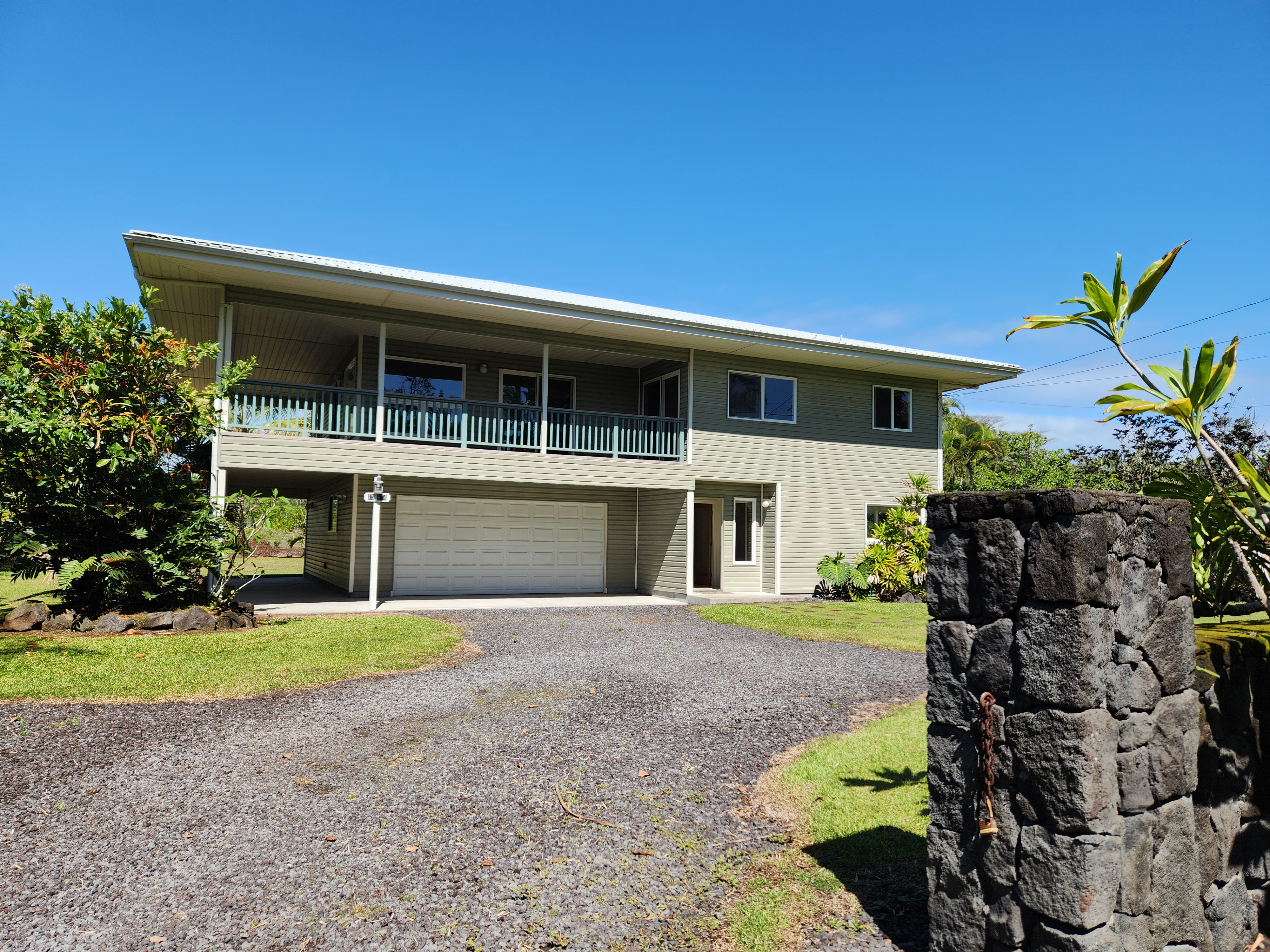 a front view of house with yard and trees in the background