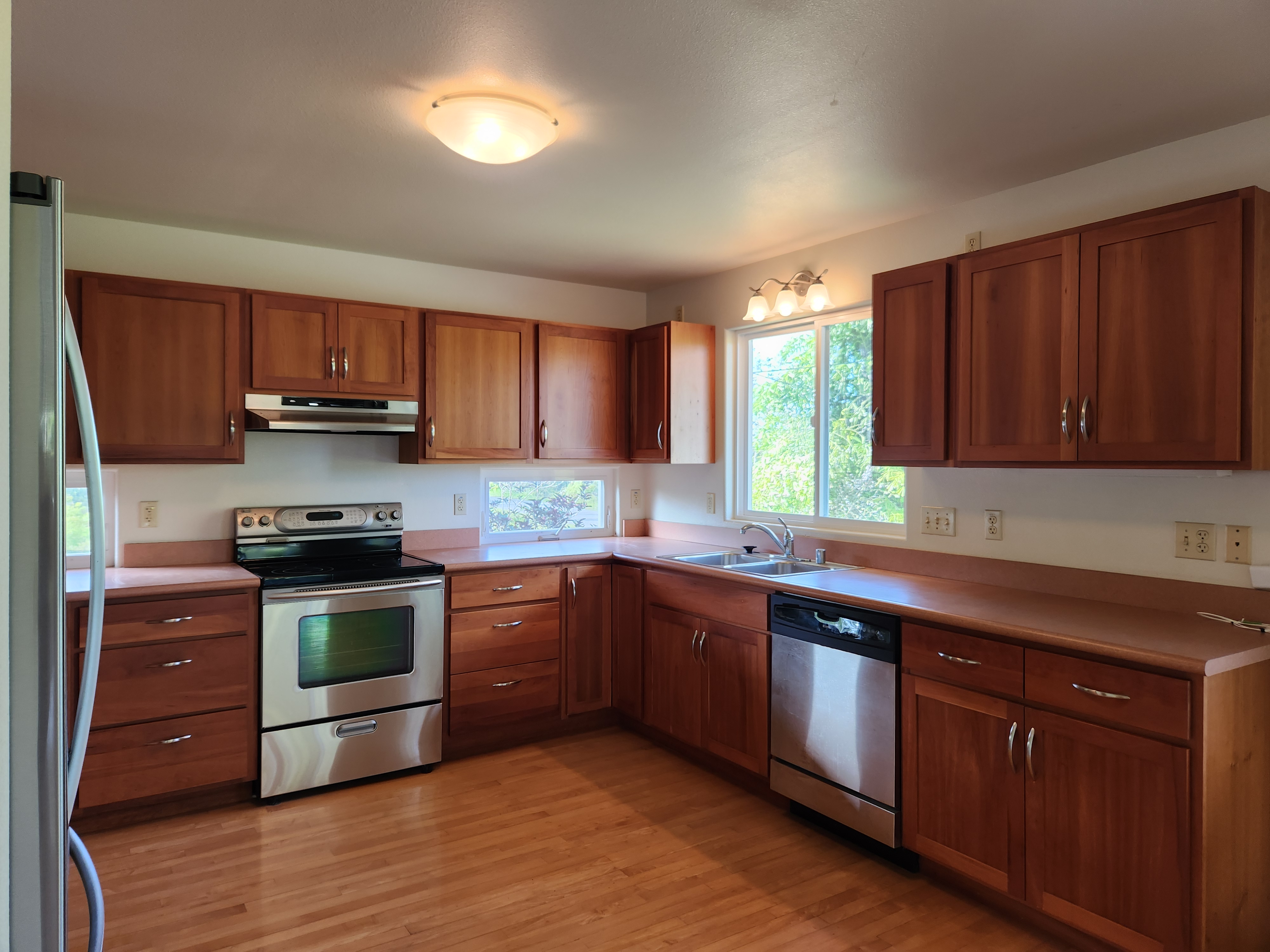 15-974 Lemiwai Road Keaau, HI 96749 - Photo 2 of 30 a kitchen with stainless steel appliances granite countertop wooden cabinets and a stove top oven