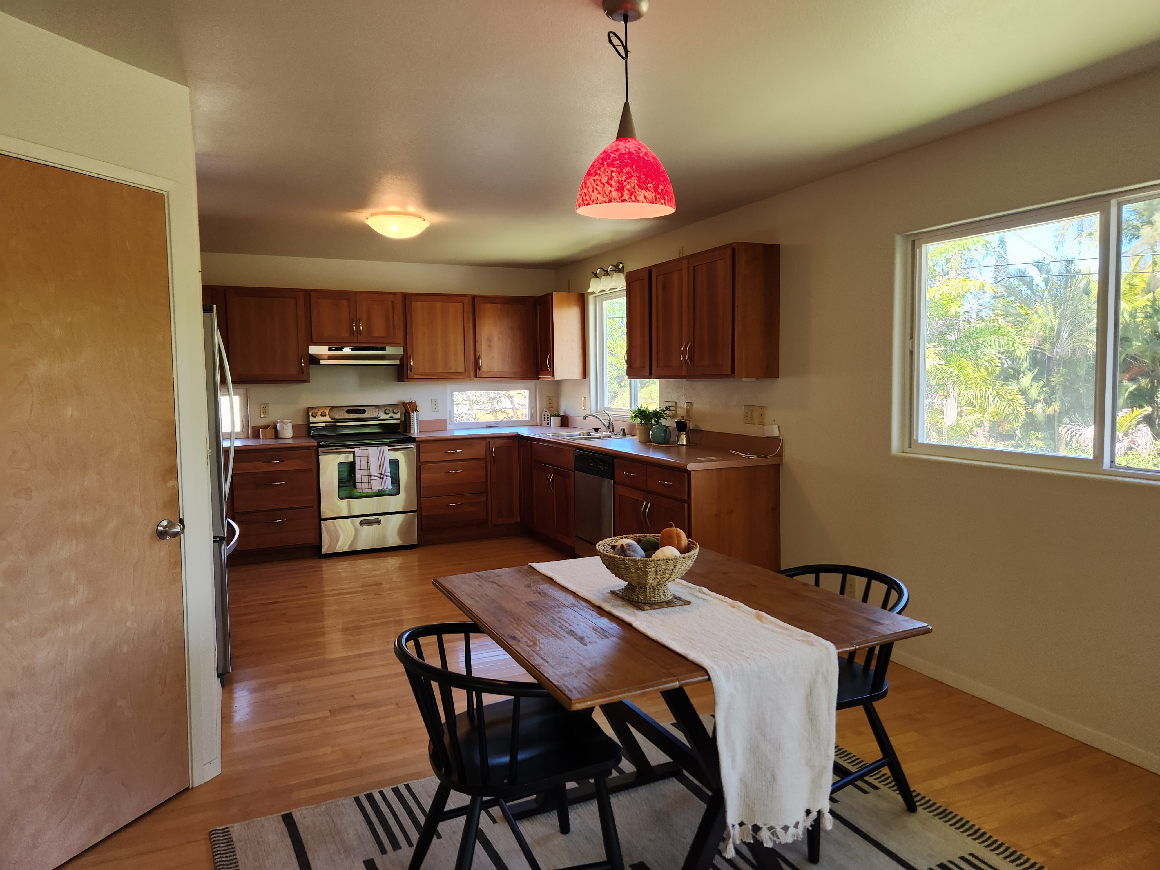 15-974 Lemiwai Road Keaau, HI 96749 - Photo 3 of 30 a kitchen with stainless steel appliances granite countertop a sink dishwasher a stove a refrigerator a microwave oven with cabinets and wooden floor