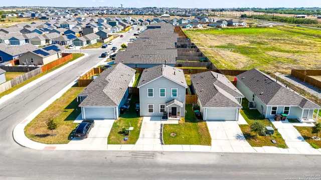 an aerial view of residential houses with outdoor space and ocean view