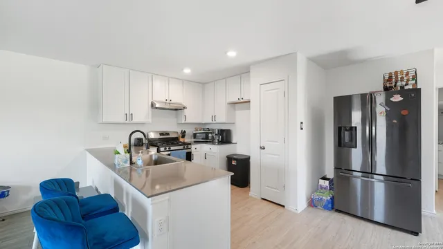 a kitchen with a refrigerator a stove a sink and a microwave