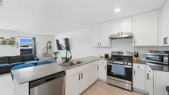 a kitchen with white cabinets and stainless steel appliances