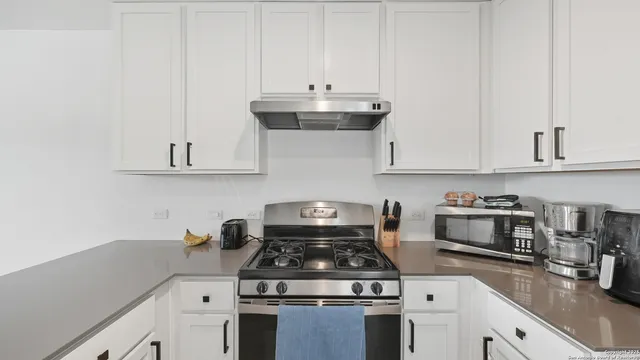 a stove top oven sitting inside of a kitchen