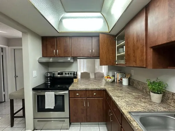 a kitchen with kitchen island granite countertop a sink stainless steel appliances and cabinets
