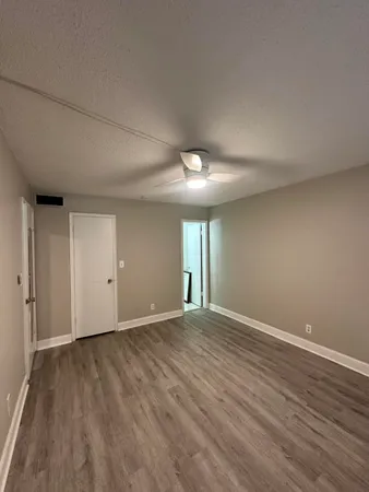 a view of an empty room with wooden floor