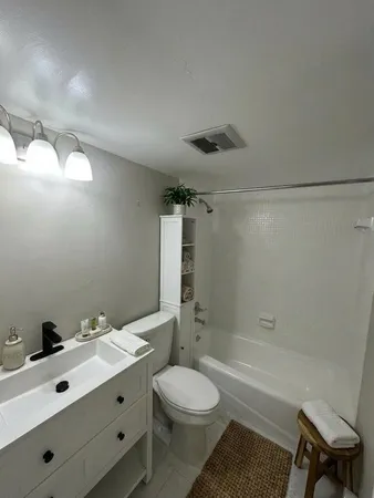 a bathroom with a toilet a sink a mirror and shower