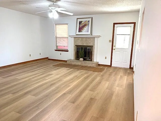 a view of an empty room with a fireplace and a window