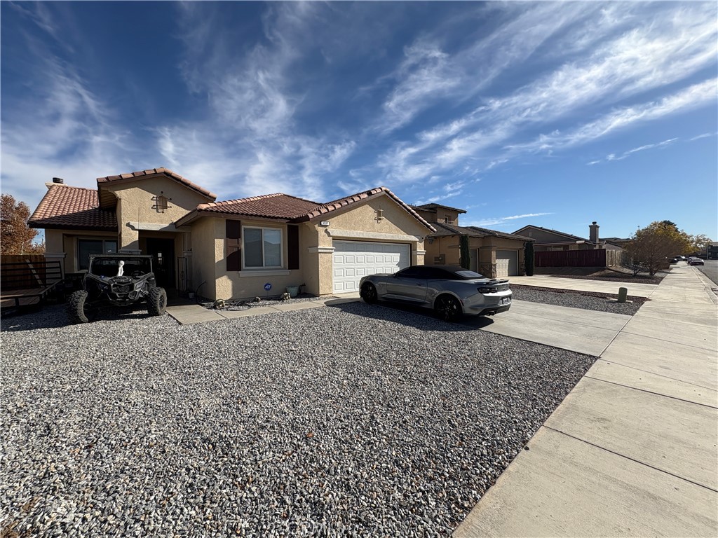 14597 Indian Paintbrush Road Adelanto, CA 92301 - Photo 1 of 1 a front view of a house with a garden