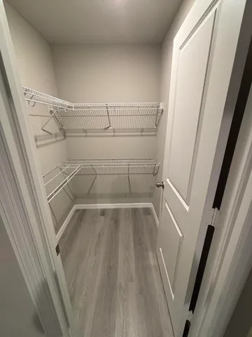 a view of walk in closet with empty racks