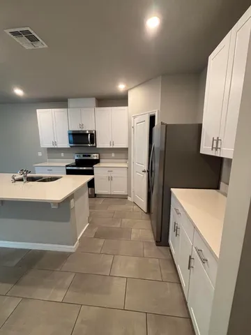 a large kitchen with a refrigerator a stove top oven a sink and dishwasher