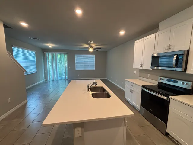a kitchen that has a sink a stove and cabinets