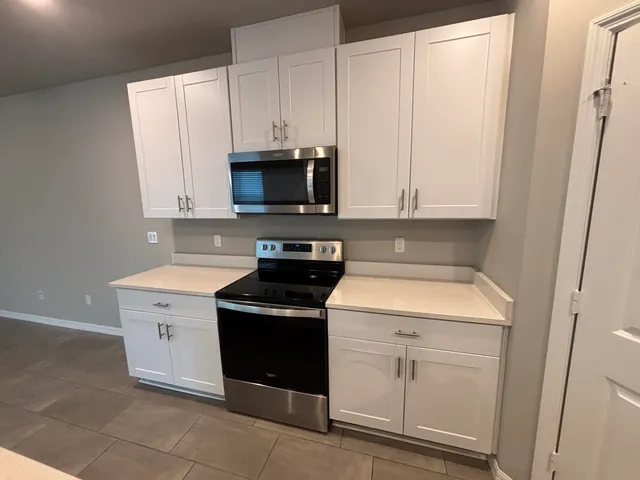 a kitchen with white cabinets stainless steel appliances and sink