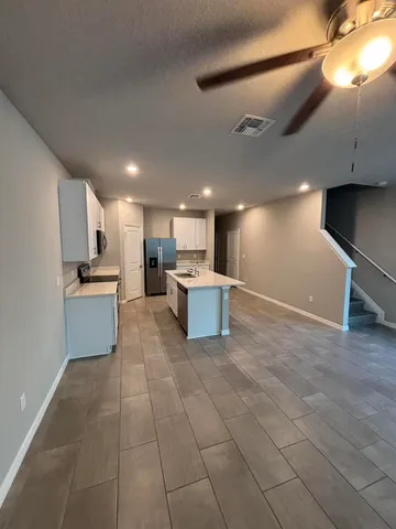 a large white kitchen with a stove a sink and a refrigerator