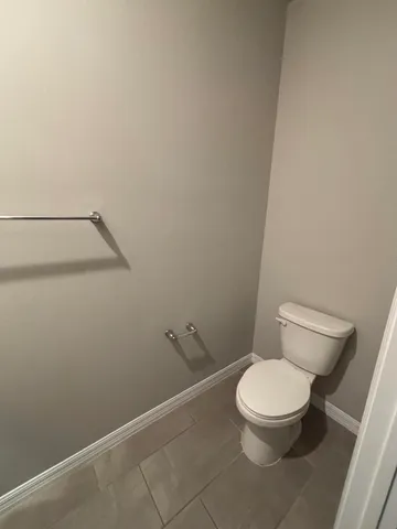 a white toilet sitting next to a shower