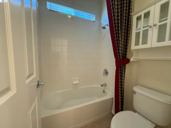 a white toilet sitting next to a bath tub