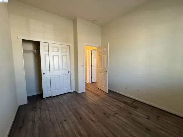 an empty room with wooden floor and closet