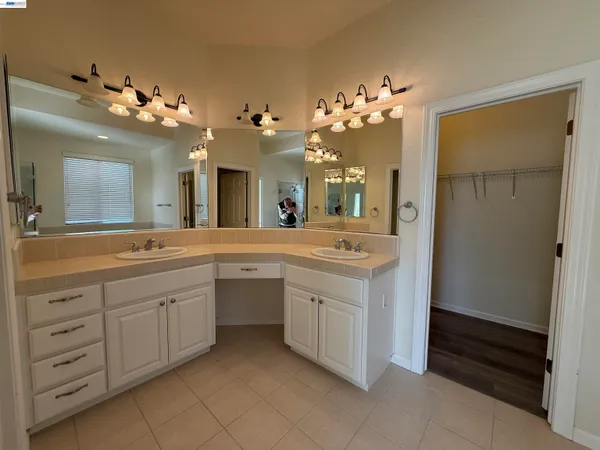 a spacious bathroom with a double vanity sink and a mirror