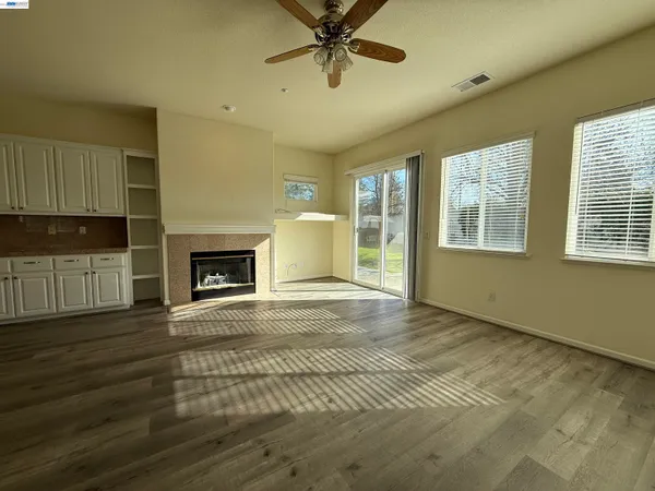 a view of an empty room with a fireplace and a window