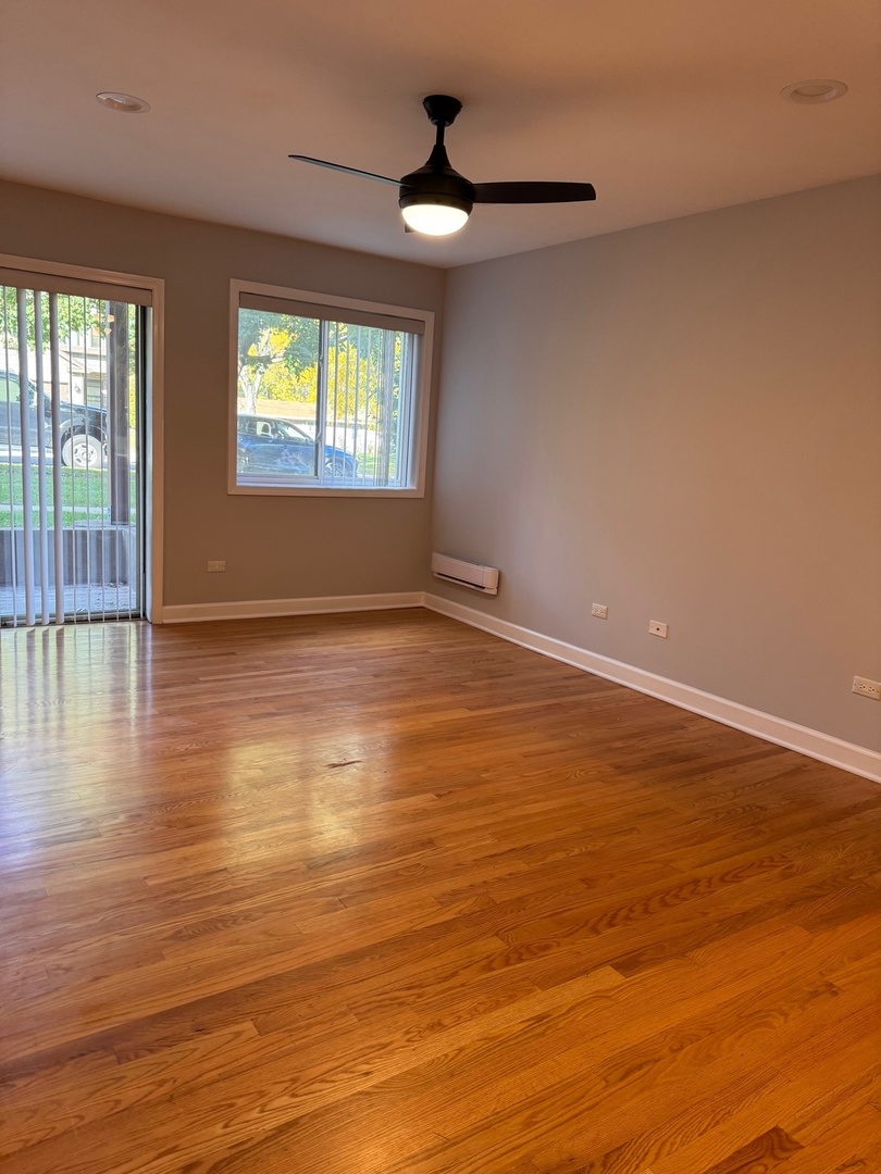 717 Strom Drive, Unit 1A West Dundee, IL 60118 - Photo 3 of 12 an empty room with wooden floor and windows