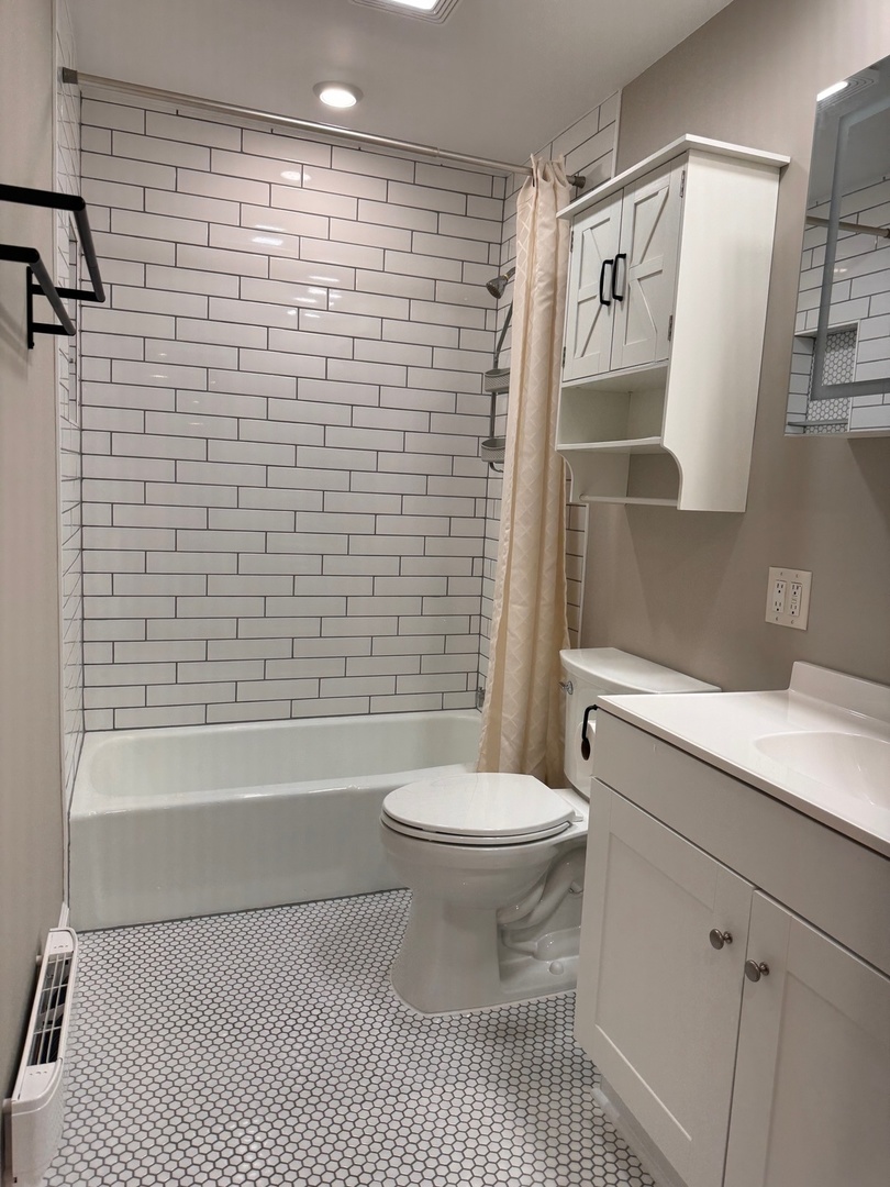 717 Strom Drive, Unit 1A West Dundee, IL 60118 - Photo 4 of 12 a bathroom with a sink a toilet and shower