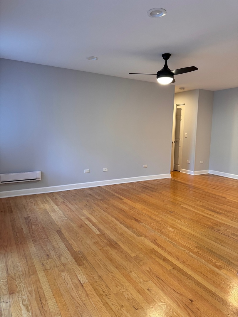 717 Strom Drive, Unit 1A West Dundee, IL 60118 - Photo 6 of 12 an empty room with wooden floor and windows