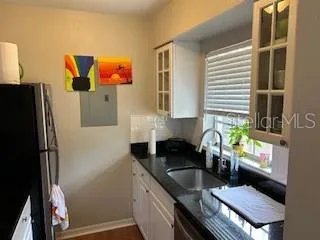 a kitchen with a sink refrigerator and window