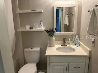 a bathroom with a sink toilet and mirror