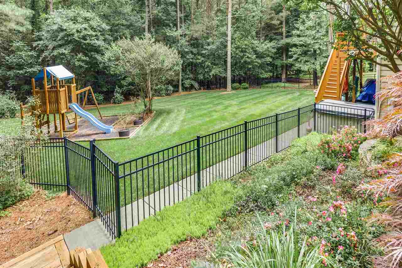 9428 Macon Road Raleigh, NC 27613 - Photo 7 of 25 Fenced back yard, playground equipment and hot tub convey with the home. Back Yard