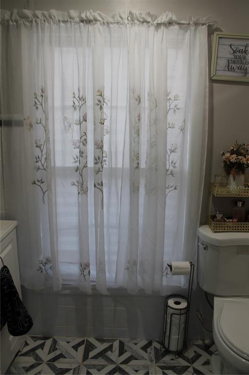 7423 Star Dust Drive Port Richey, FL 34668 - Photo 16 of 23 a bathroom with a sink a toilet and shower curtain