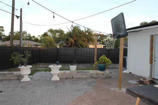 a view of backyard with table and chairs and a large tree