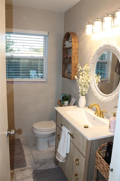 7423 Star Dust Drive Port Richey, FL 34668 - Photo 4 of 23 a bathroom with a toilet sink and mirror