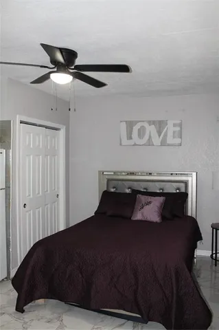 a bedroom with a bed and a ceiling fan