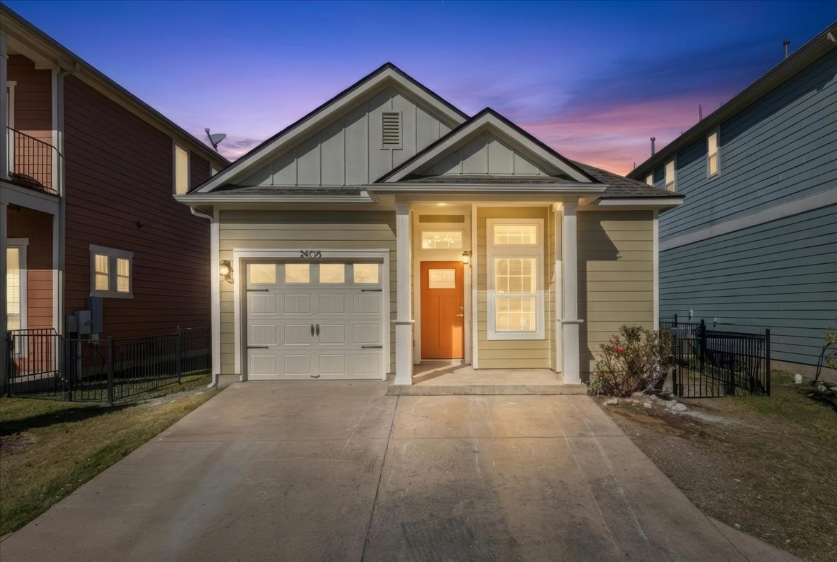View of front of house with board and batten siding, concrete driveway, and an attached garage