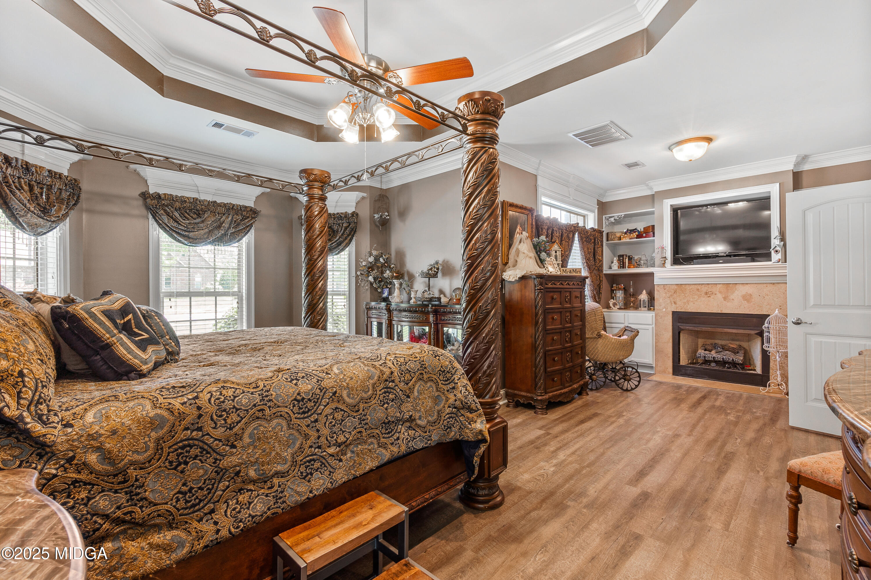 105 River Rock Court Perry, GA 31069 - Photo 32 of 61 a bedroom with a bed a flat screen tv and fireplace