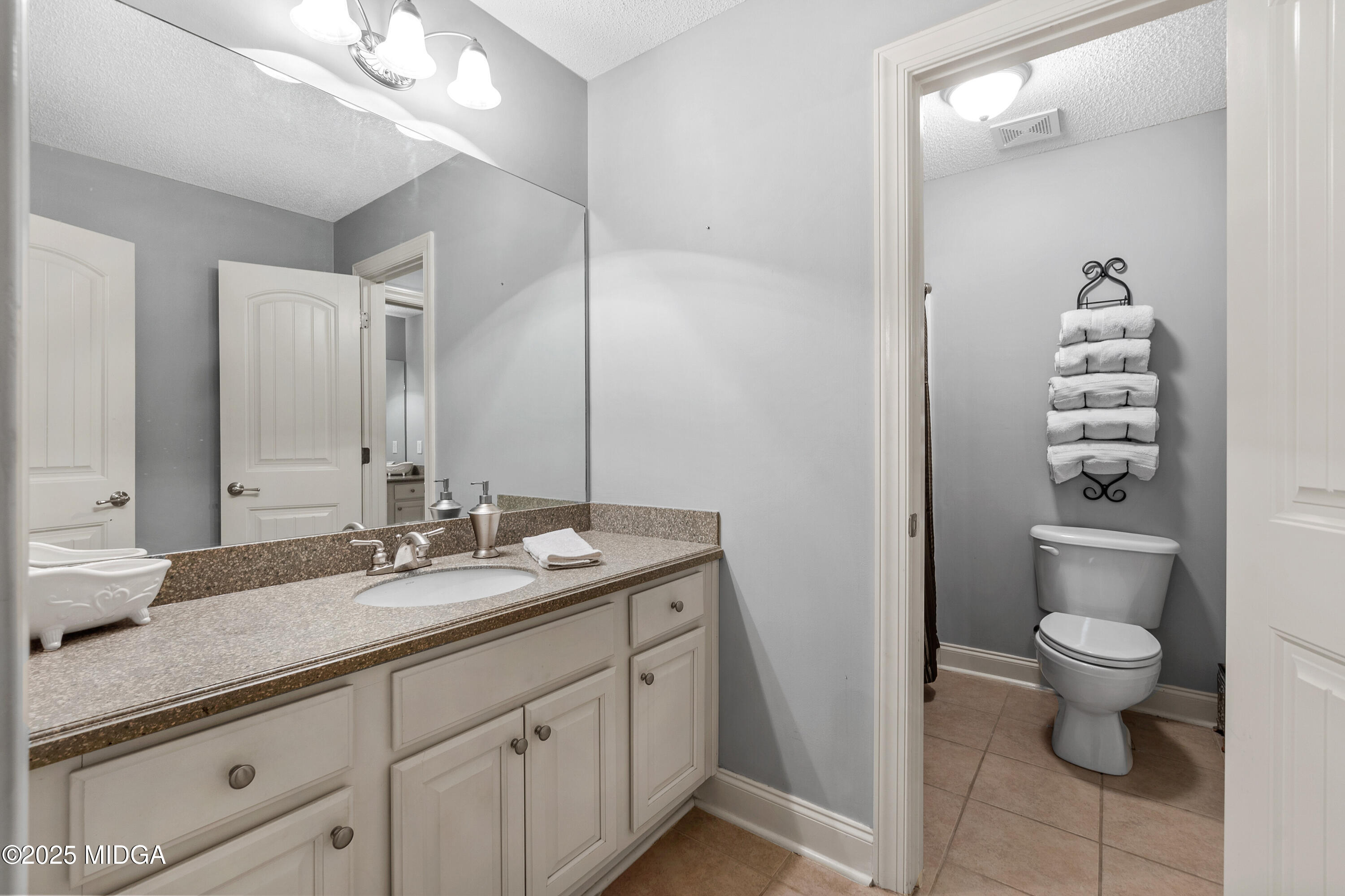 105 River Rock Court Perry, GA 31069 - Photo 47 of 61 a bathroom with a granite countertop sink a toilet and a mirror