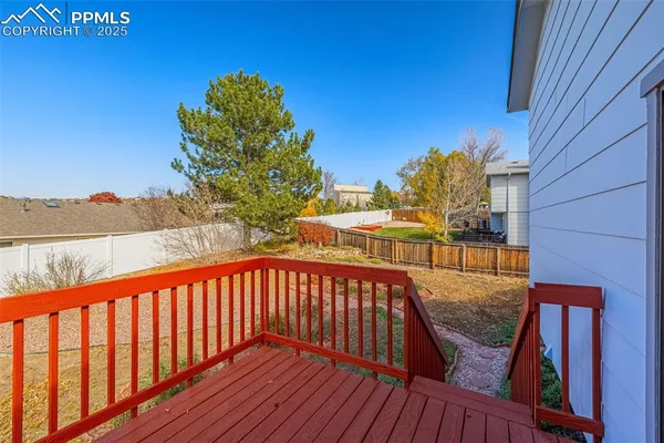 a balcony with wooden floor table and chairs