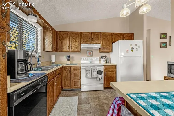 a kitchen with a sink a stove top oven and refrigerator