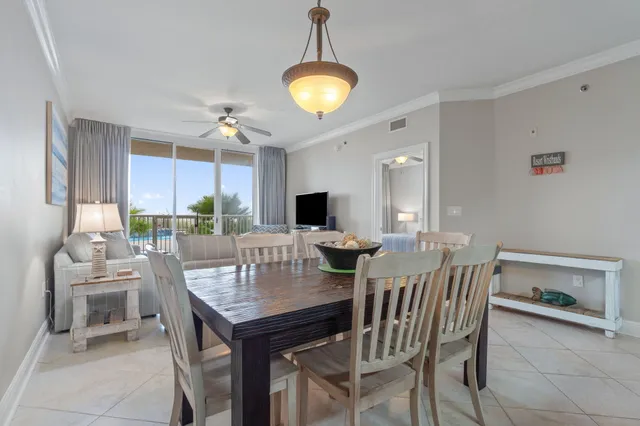 a kitchen with stainless steel appliances granite countertop a stove a refrigerator a sink a dining table and chairs