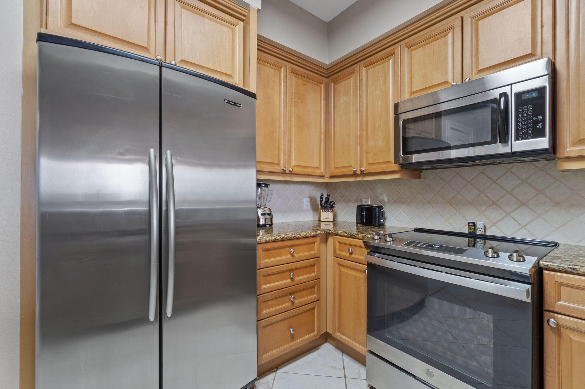1150 Santa Rosa Boulevard, Unit 113 Fort Walton Beach, FL 32548 - Photo 20 of 71 a kitchen with stainless steel appliances granite countertop a refrigerator stove and microwave