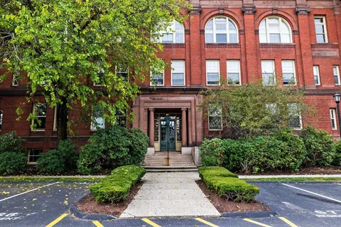front view of a brick house with a small yard