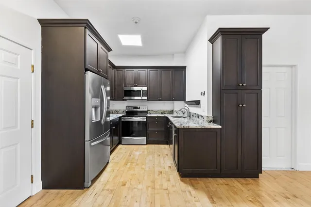 a kitchen with stainless steel appliances granite countertop a refrigerator and a stove