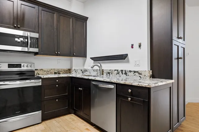 a kitchen with stainless steel appliances granite countertop a sink stove and microwave