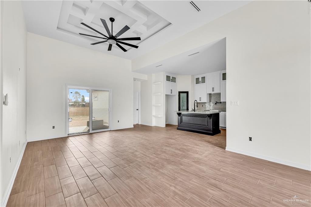 3516 East Alexa Street Edinburg, TX 78542 - Photo 16 of 25 a view of a livingroom with a hardwood floor a ceiling fan and windows