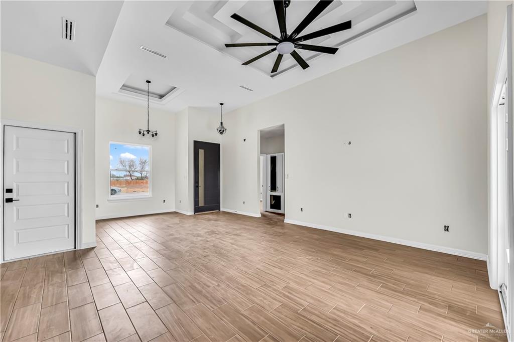 3516 East Alexa Street Edinburg, TX 78542 - Photo 8 of 25 an empty room with wooden floor and windows