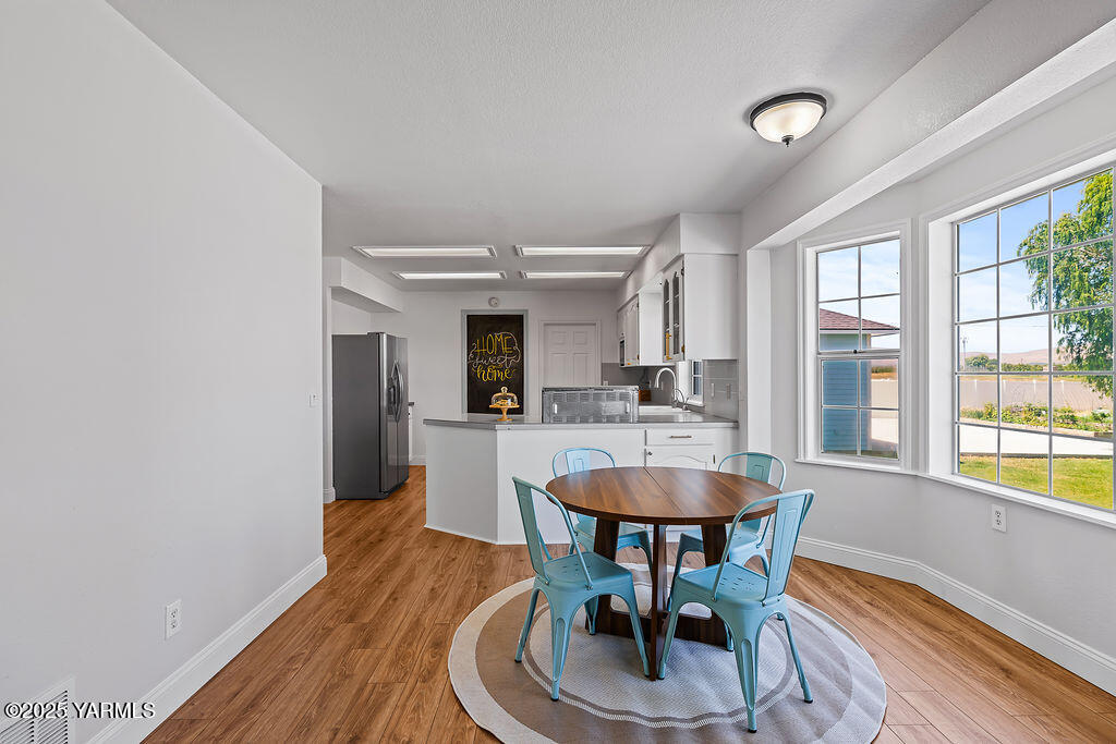 11809 Occidental Road Yakima, WA 98908 - Photo 18 of 60 a dining room with furniture a chandelier and wooden floor