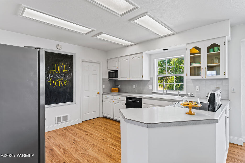 11809 Occidental Road Yakima, WA 98908 - Photo 19 of 60 a kitchen with a stove a refrigerator and a sink