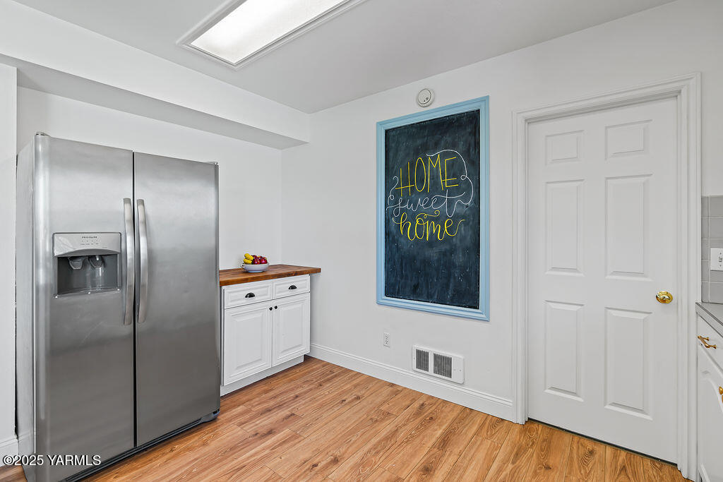 11809 Occidental Road Yakima, WA 98908 - Photo 22 of 60 a kitchen with white cabinets and refrigerator