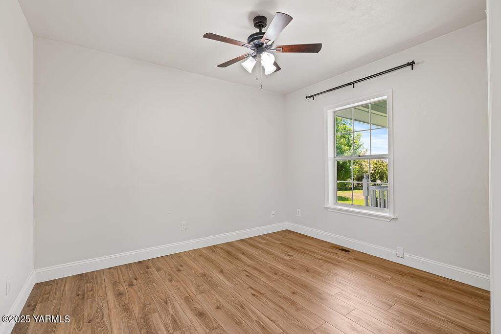 11809 Occidental Road Yakima, WA 98908 - Photo 23 of 60 an empty room with a window and a ceiling fan