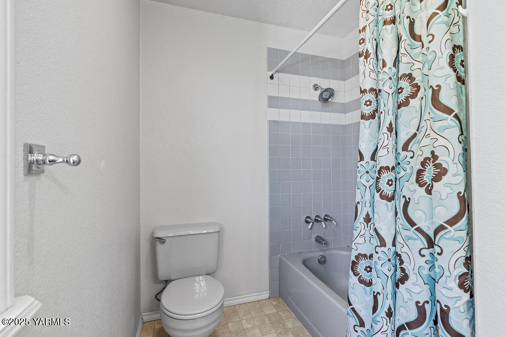 11809 Occidental Road Yakima, WA 98908 - Photo 31 of 60 a bathroom with a toilet and a shower curtain